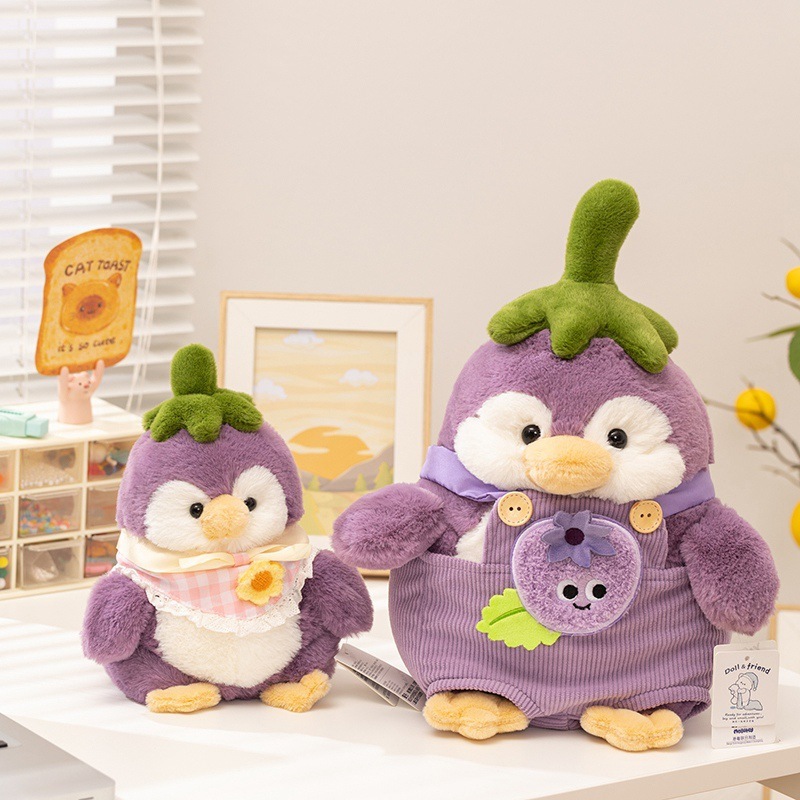 Eggplant penguin plush toy in blueberry outfit displayed on a desk, soft stuffed animal for cozy room decor and gifting