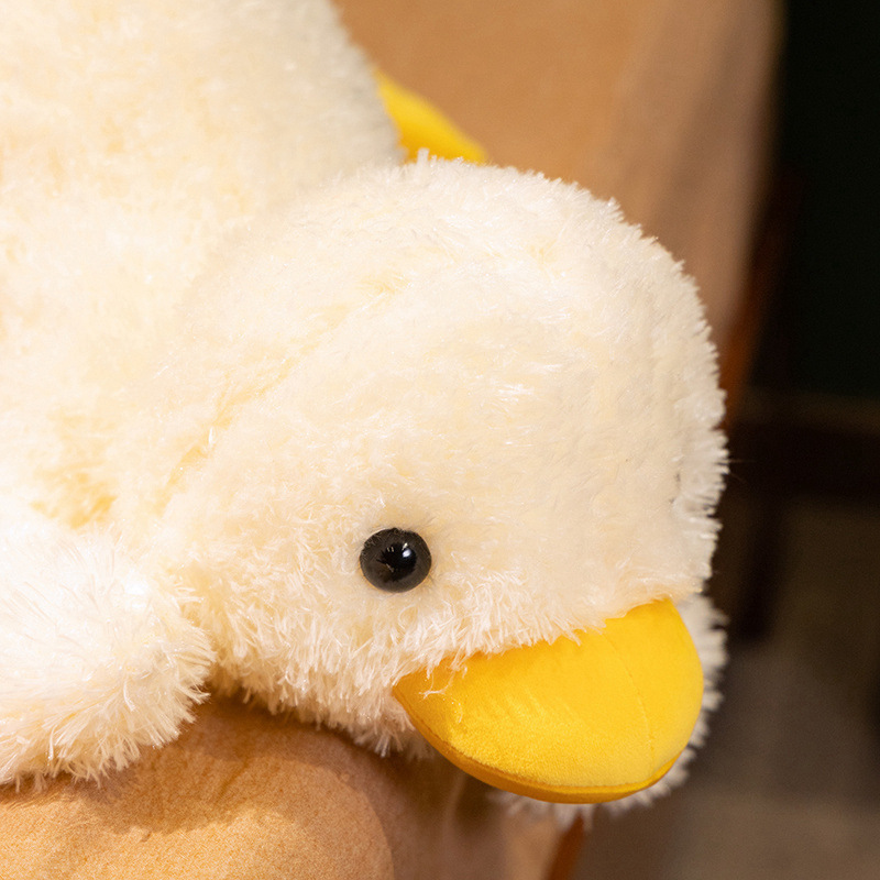 Close-up of the lying white duck plush pillow featuring fluffy plush fabric, round eyes, and a soft yellow beak