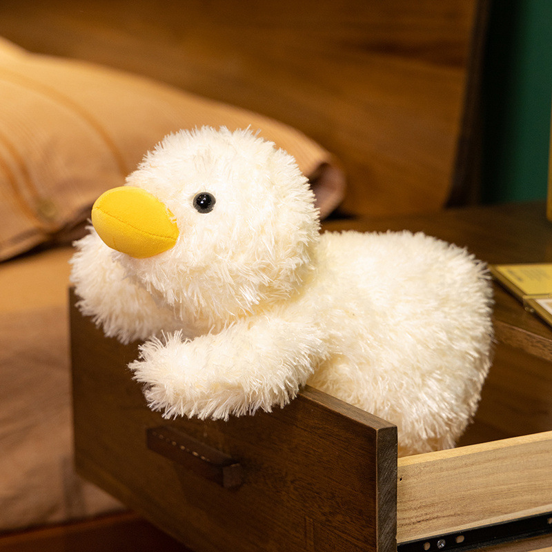 Lying white duck plush pillow resting on a bedside drawer, showing soft fluffy texture and cozy design, ideal as a decorative plush pillow for bedroom comfort and relaxation