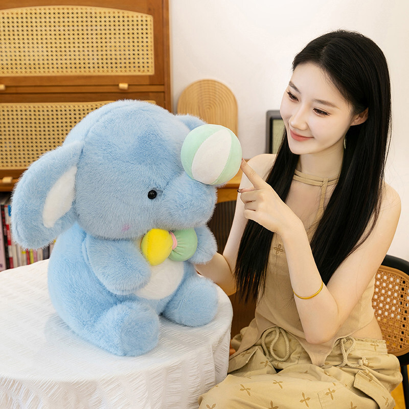 Happy elephant plush toy with soft plush fabric and bow detail, shown in a cozy home setting, highlighting its rounded shape, gentle texture, and comforting companion design