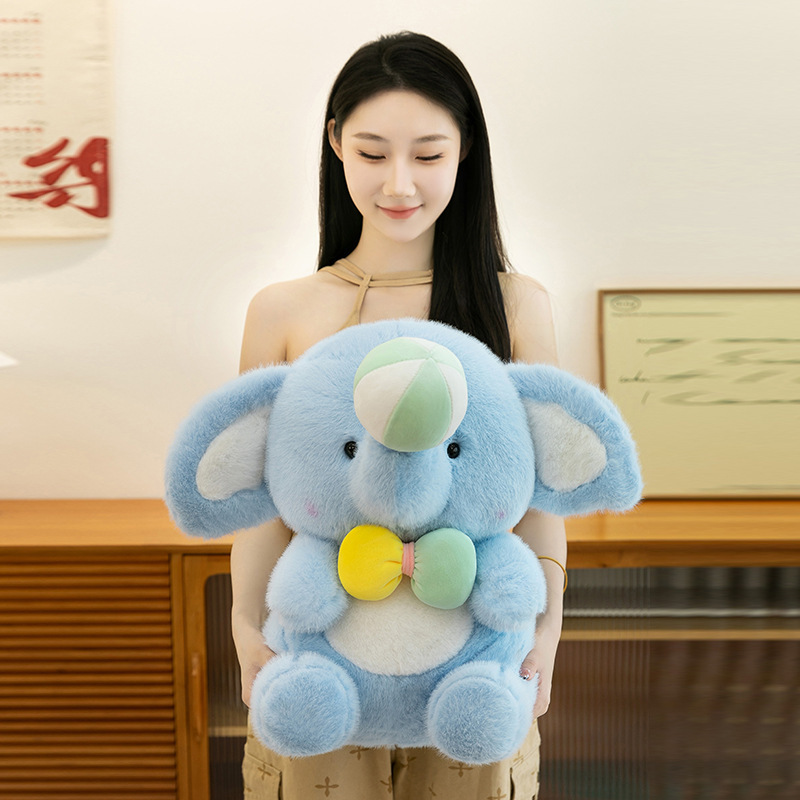 Large happy elephant plush toy in 45cm size with soft blue plush fabric, round sitting shape and pastel bow detail, designed for hugging and comforting, creating a cozy and warm home atmosphere