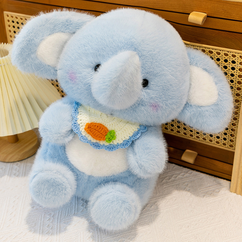 Blue happy elephant plush toy sitting beside wooden furniture, featuring soft plush fabric, rounded body, floppy ears, and a cozy decorative look for home spaces