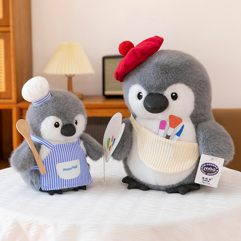 Chef and painter penguin plush toys displayed side by side, featuring soft plush texture, playful outfits, and cozy home decor styling