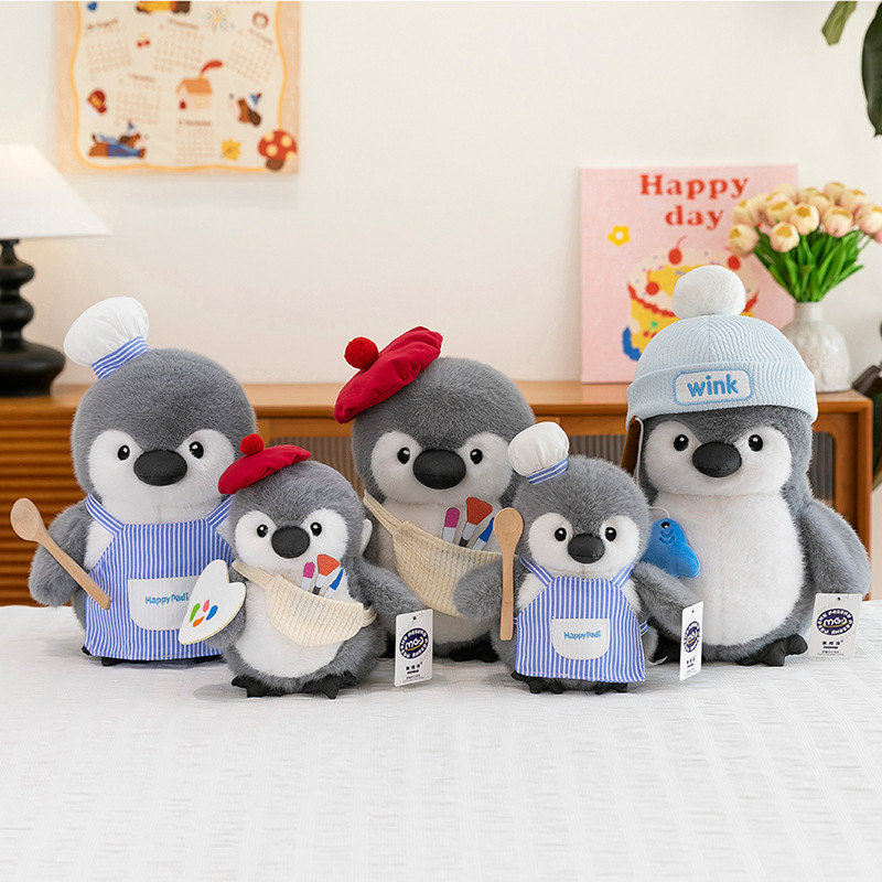 Chubby penguin plush toys in chef, painter and fishing styles displayed together on a table, showing different sizes and outfits for cozy home decor and gift ideas