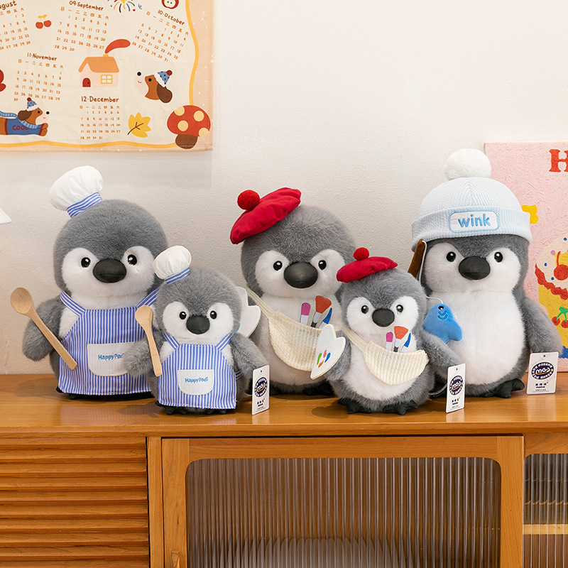 Chubby penguin plush toys in chef, painter and fishing designs arranged on a wooden cabinet, creating a warm and playful home decor atmosphere