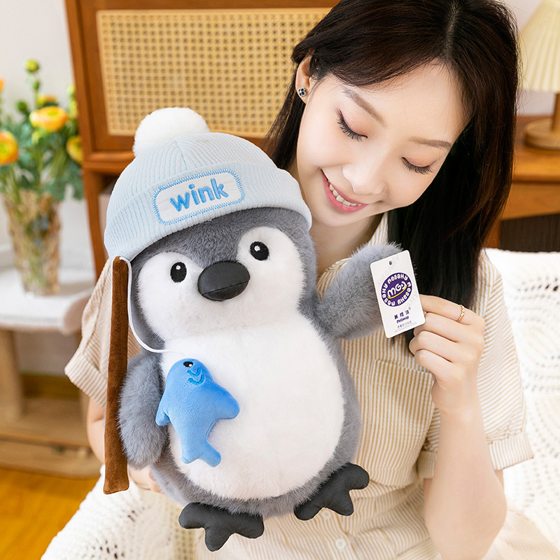 Fishing penguin plush toy with knit hat and fish accessory, soft plush texture and rounded body, designed for hugging and cozy home decor