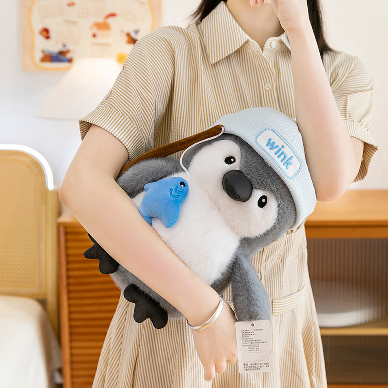Fishing penguin plush toy held in arms, chubby body with soft plush fabric, comforting cuddle experience for relaxation and daily use