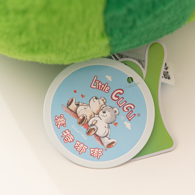 Little CuCu brand tag attached to fruit plush pillow