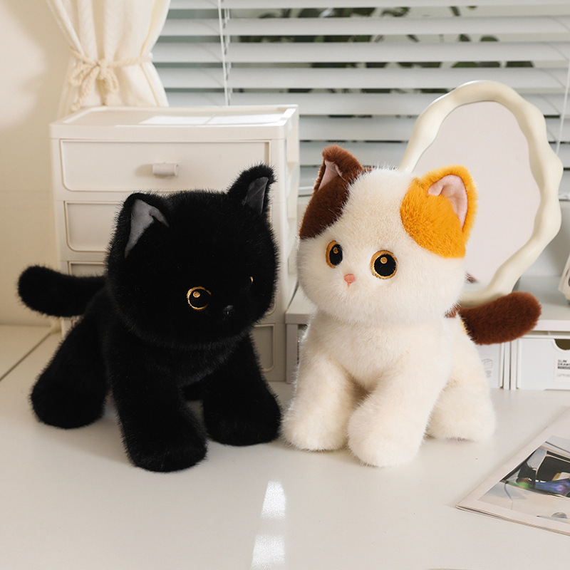 Poseable cat plush toys in black and calico designs arranged in standing and sitting poses on a desk surface, soft plush fabric with detailed facial features