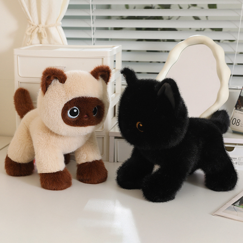 Poseable cat plush toys in Siamese and black designs displayed on a desk in a cozy indoor setting, soft fluffy texture with standing pose