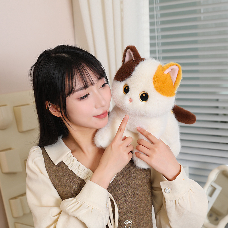 Poseable calico cat plush toy held in arms in a cozy indoor setting, soft fluffy fabric with detailed eyes and compact 30cm size for cuddling and display