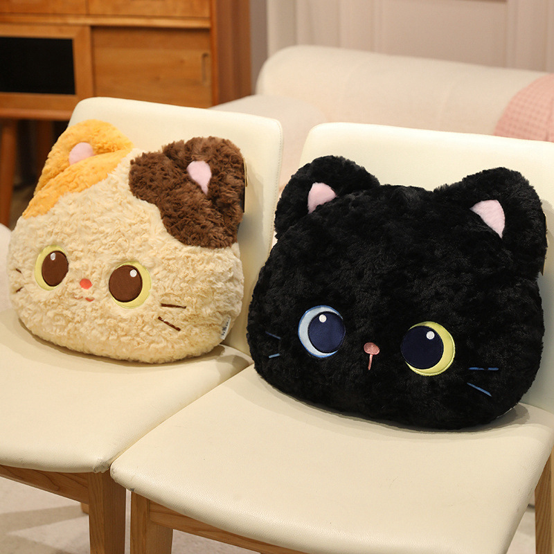 Black and calico cat head plush pillows placed side by side on cushioned chairs, showcasing plush fabric, detailed facial embroidery and decorative use for sofa, bedroom or lounge spaces