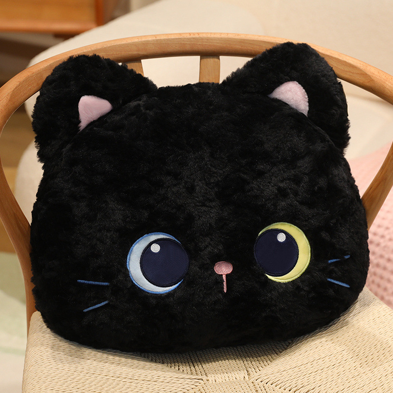 Black cat head plush pillow on wooden chair with soft fluffy texture and embroidered eyes