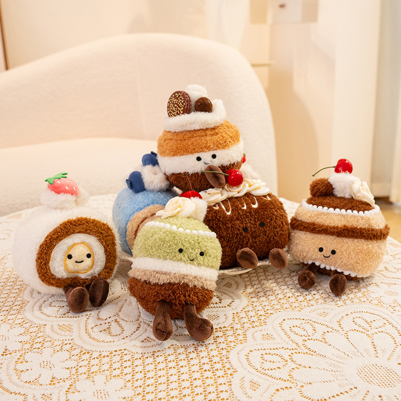 Assorted dessert plush toys including Swiss rolls, chocolate cake and matcha cake displayed on lace table, cute 13 cm stuffed dessert decorations for desk or home decor