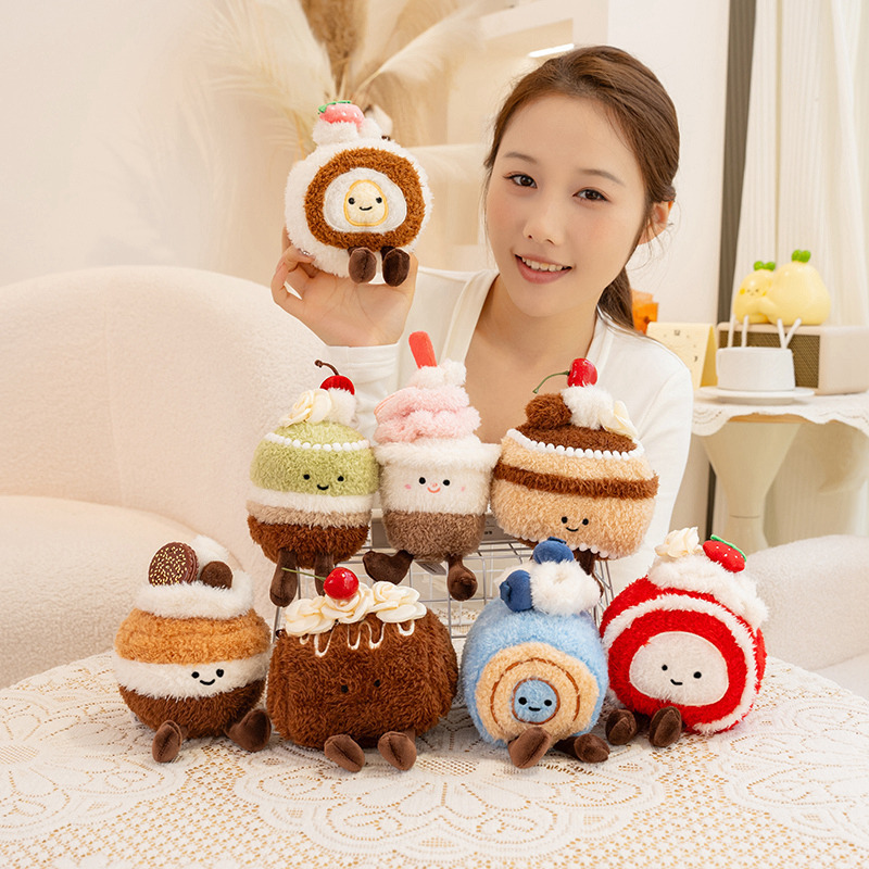Dessert plush toy series including chocolate cake, Swiss roll, cupcake and macaron cake designs displayed together on a cozy home table setting