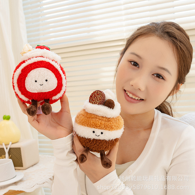 Dessert plush toy featuring strawberry Swiss roll and macaron cake designs with soft plush texture, cute embroidered face and dangling legs, displayed in cozy home setting