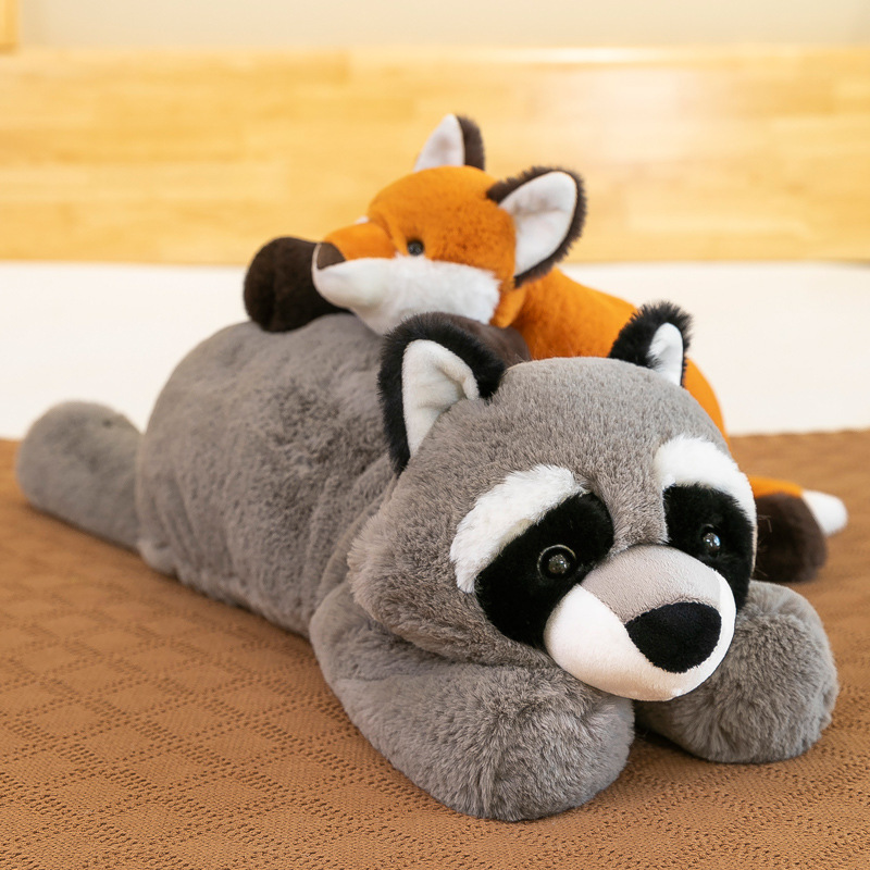 Fox and raccoon lazy lying plush toys layered on a bed, long soft stuffed animals for hugging, relaxation and bedroom decor