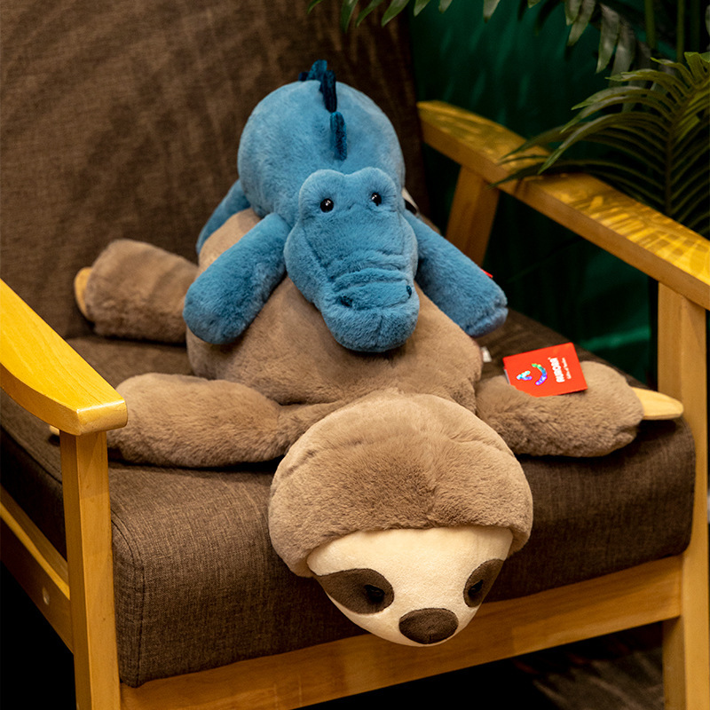 Sloth and crocodile lazy lying plush toys layered on a chair, highlighting elongated body shape and cozy home decor setting
