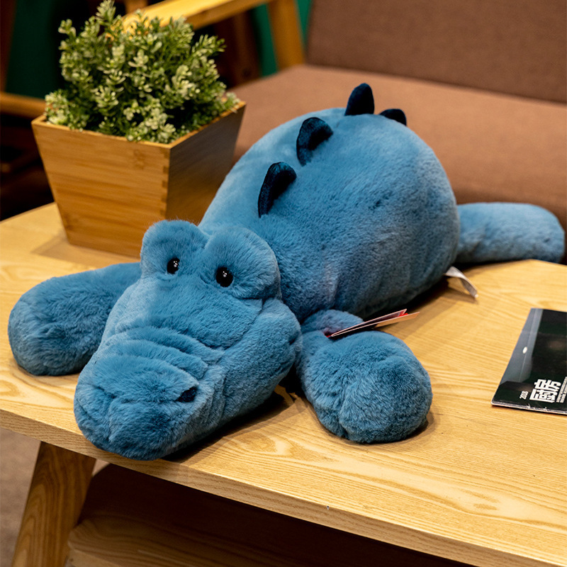 Crocodile lazy lying plush toy on wooden table, soft long body stuffed animal designed for hugging, relaxing, and playful home styling