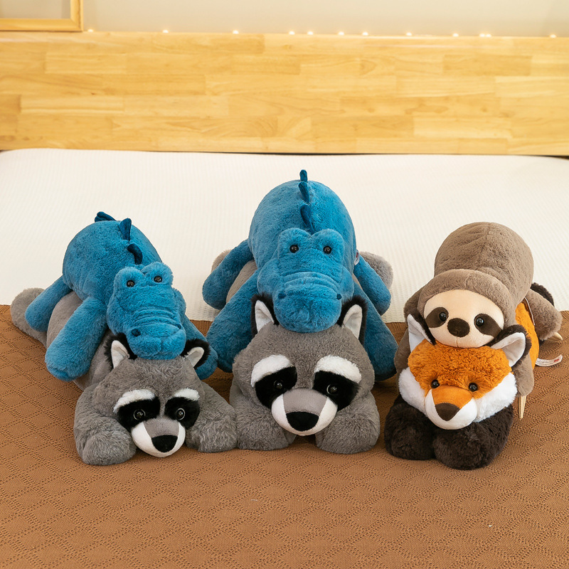 Lazy lying animal plush toys including crocodile, raccoon, fox and sloth arranged on a bed, soft stuffed animals in multiple sizes for cozy bedroom decor and hugging comfort