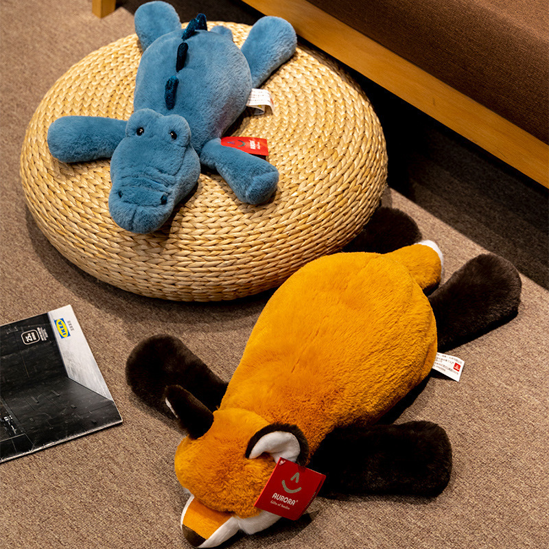 Fox and crocodile lazy lying plush toys displayed on a woven floor cushion and carpet, showing soft fabric texture and relaxed lounging style