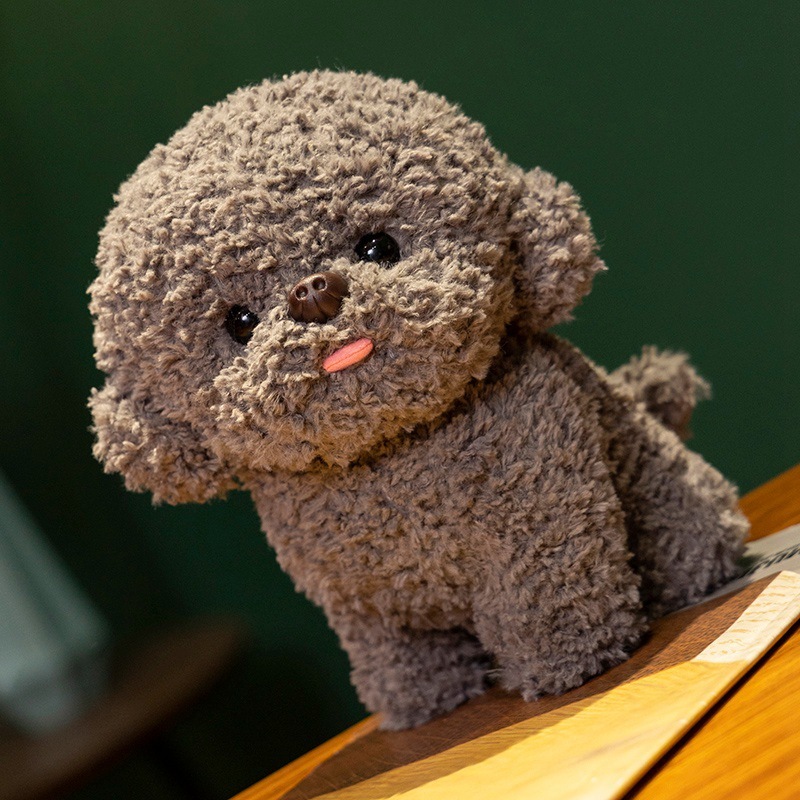 Gray Bichon Frise plush toy on wooden table with fluffy teddy plush fabric, round face, small tail and tongue-out expression, soft stuffed dog for home decor or gifting