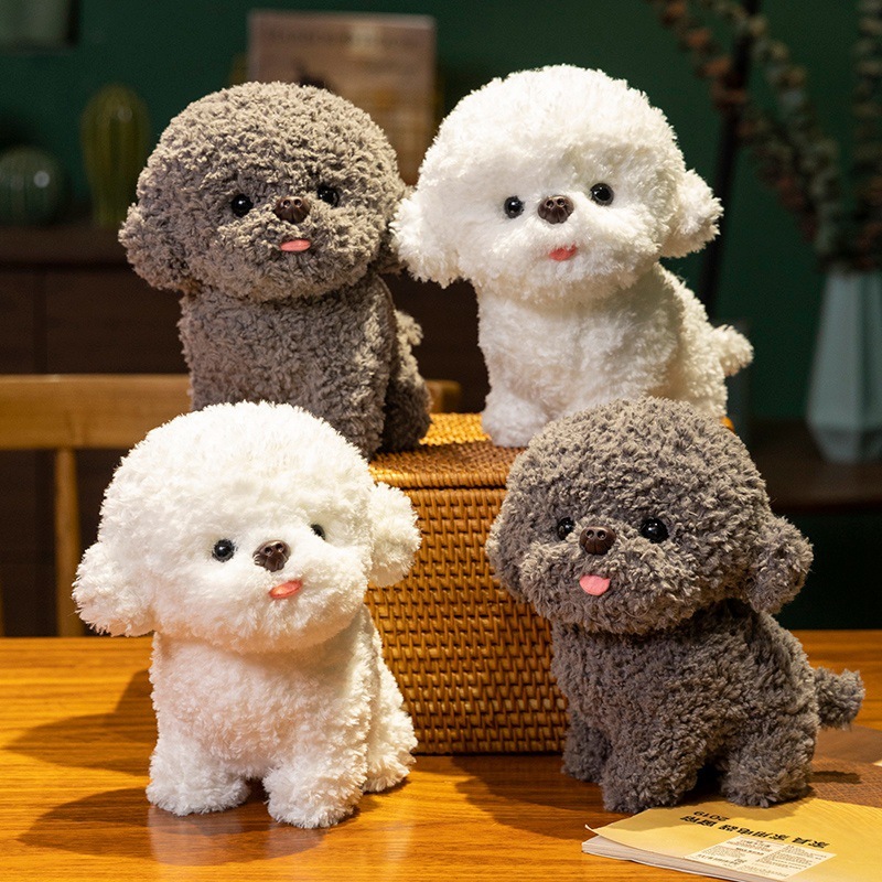 Gray and white Bichon Frise plush toys with curly teddy plush texture displayed on a wooden table, featuring tongue out expression and soft fluffy appearance