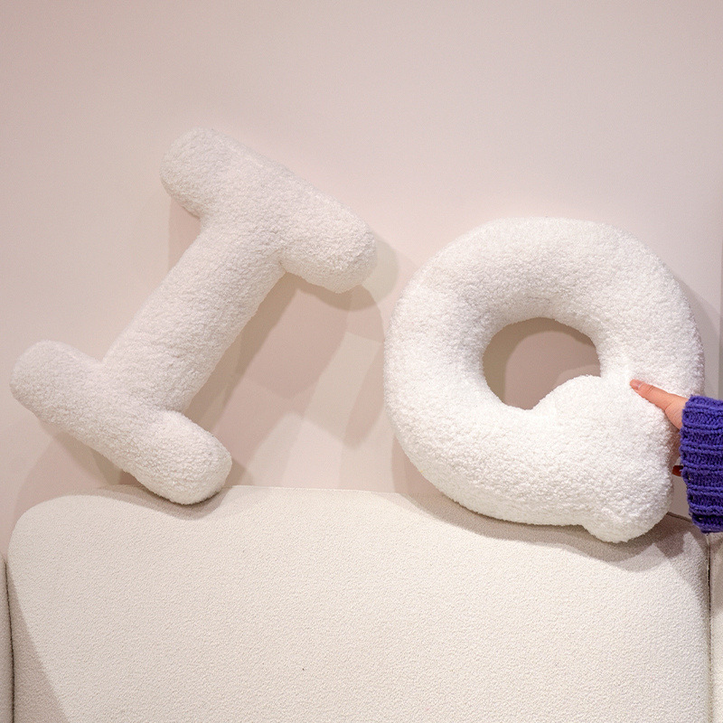 Teddy plush alphabet letter pillows spelling IQ displayed on a sofa, soft texture and modern home decor style