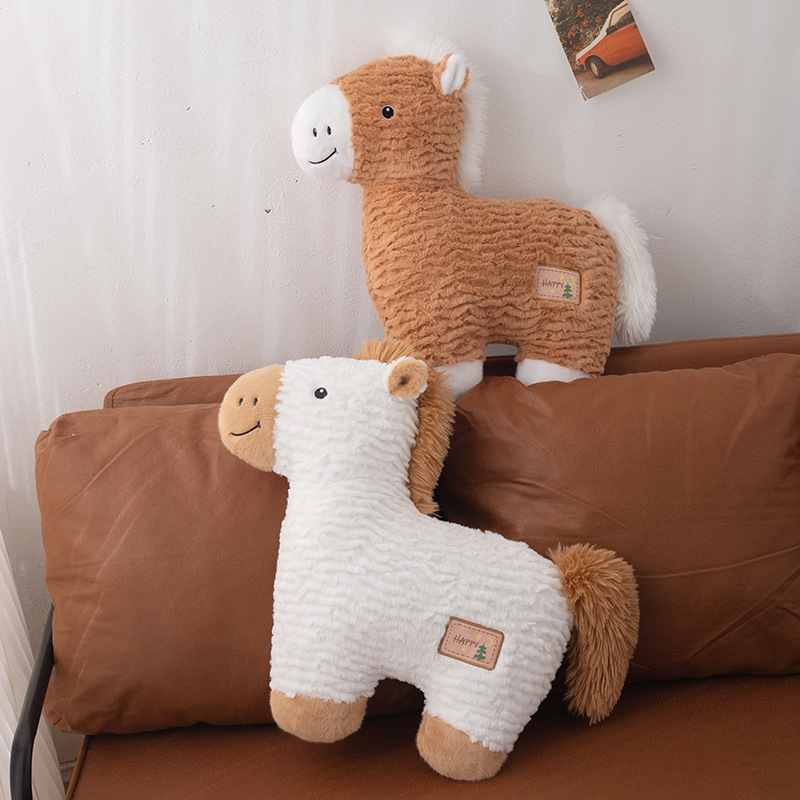 Brown and white horse plush pillows displayed on a brown leather sofa, featuring soft textured plush fabric, fluffy mane and tail, and a cozy home decor setting