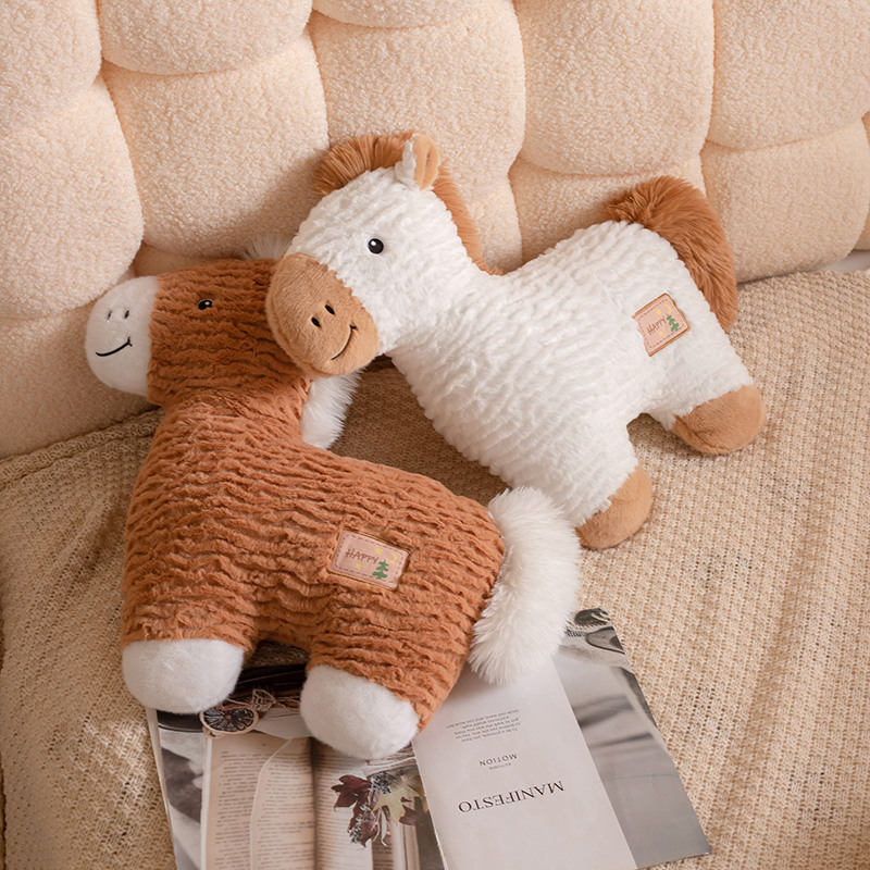 Soft horse plush pillows in white and brown resting on a bed, fluffy animal cushions ideal for hugging and decor