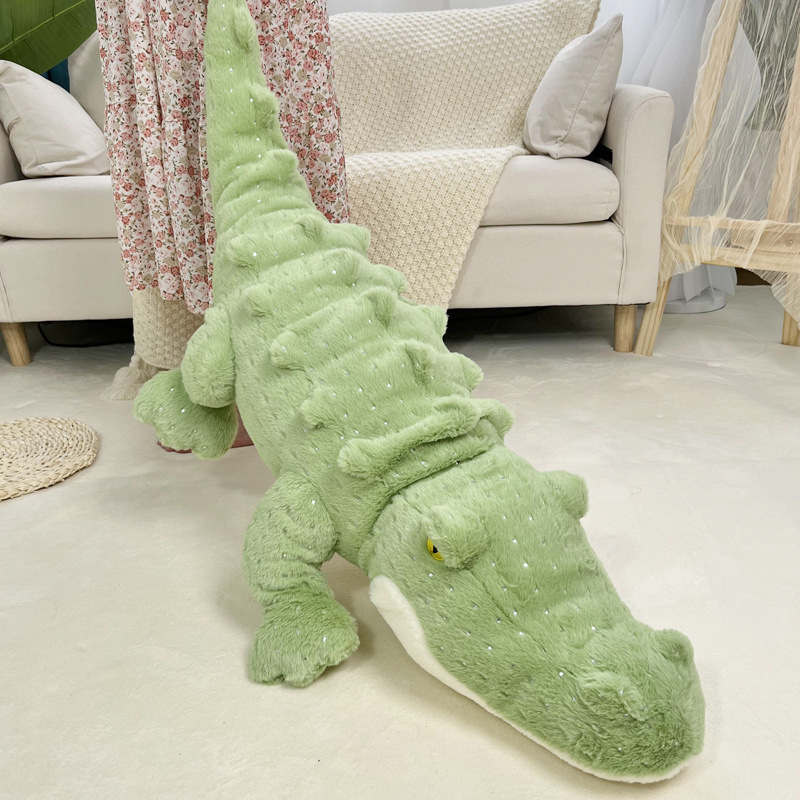 Crocodile plush toy in long body design placed on floor near sofa, soft green fabric with textured details, cozy home decor setting