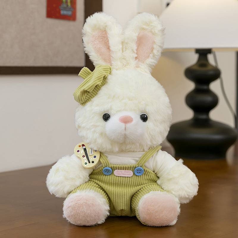 Mora bunny plush toy in green corduroy overalls with matching bow, soft fluffy rabbit stuffed animal