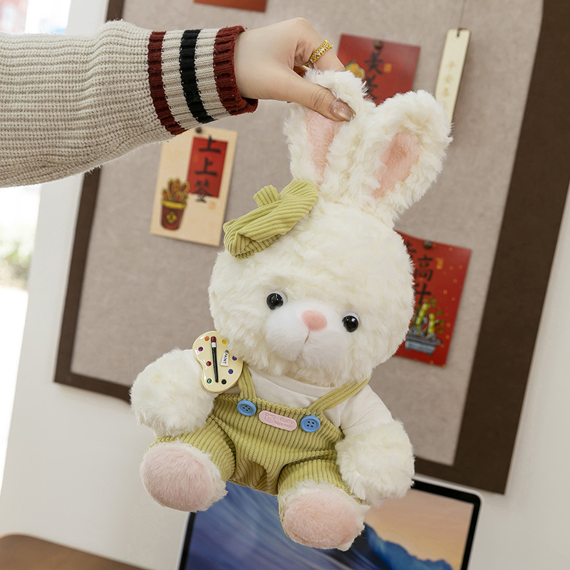 Mora bunny plush toy in green outfit gently held by the ears, showing lightweight design and soft stuffed texture