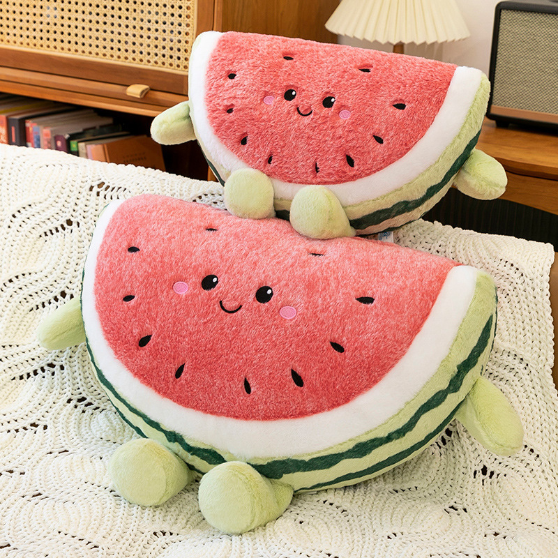 Two watermelon plush pillows arranged together on sofa in warm home setting