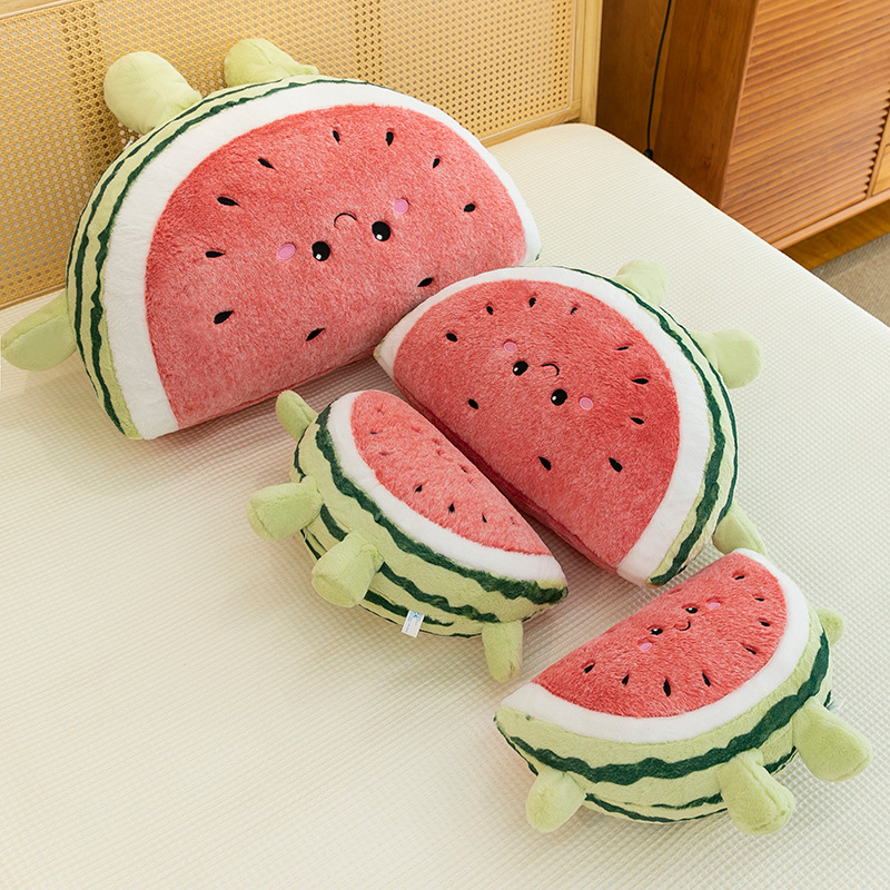 Watermelon plush pillows in multiple sizes arranged on bed from top view