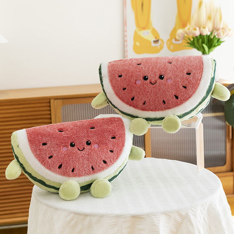 Watermelon plush pillows arranged on table with layered display in warm home setting