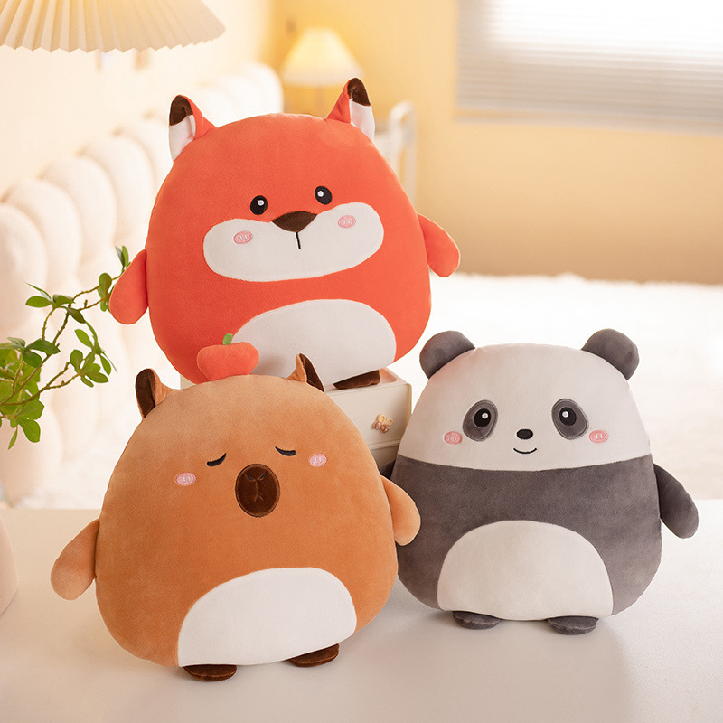 Fox, capybara, and panda 36cm hess animal plush pillows displayed on a bedside table in a softly lit bedroom scene