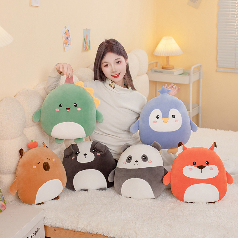 Round 36cm hess animal plush pillows including fox, capybara, dog, penguin, dinosaur, and panda displayed on a soft bed in a cozy home setting