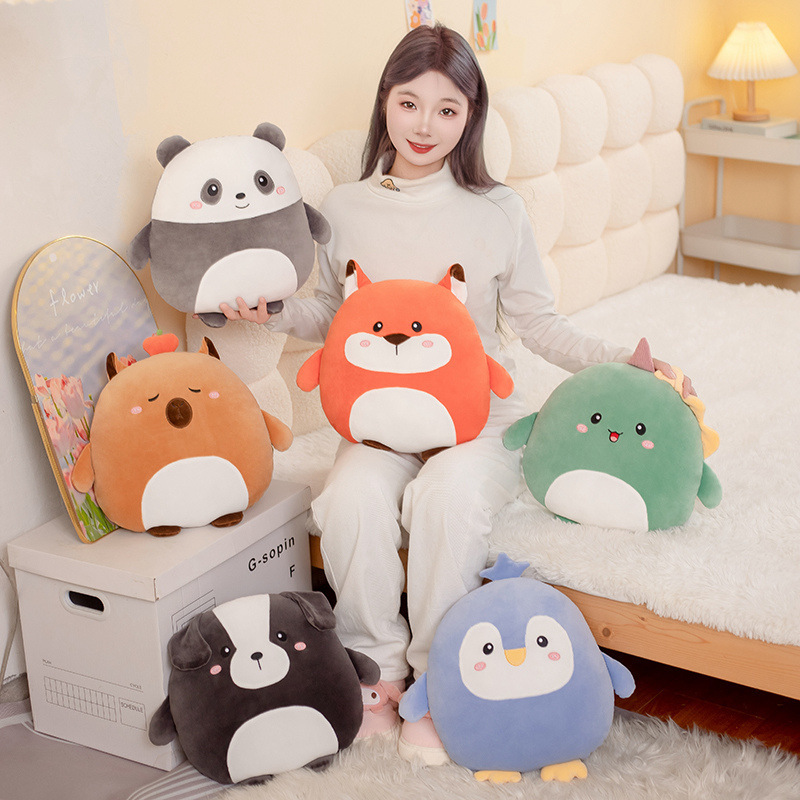 Hess animal plush pillows in fox, capybara, dog, penguin, dinosaur, and panda designs displayed on a bed and floor in a cozy bedroom setting