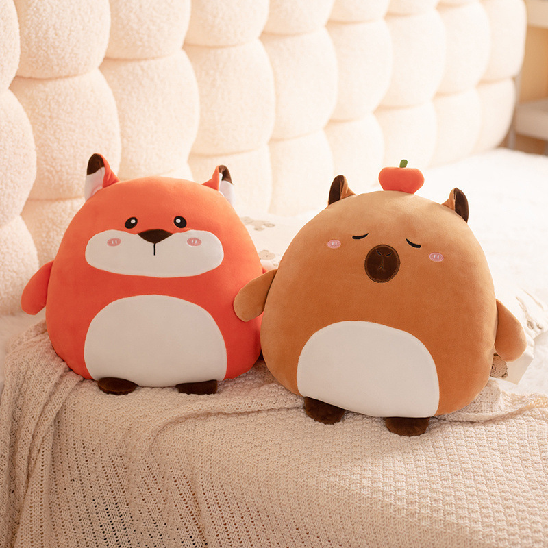 Fox and capybara 36cm hess animal plush pillows placed on a soft bed with knitted blanket in a warm and cozy bedroom setting