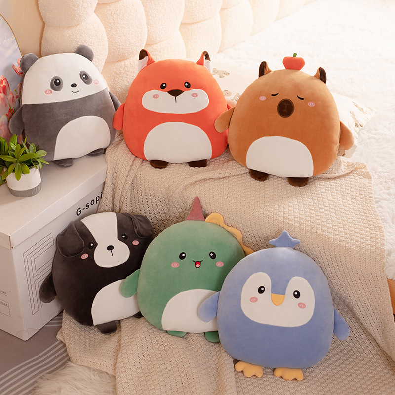 Round 36cm hess animal plush pillows in fox, capybara, dog, penguin, dinosaur, and panda designs arranged on a soft bed in a warm and cozy bedroom setting