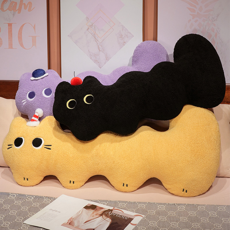 Cloud cat long plush pillow in black, yellow and purple, soft elongated body cushions stacked on a bed showcasing curved shape and playful cat design