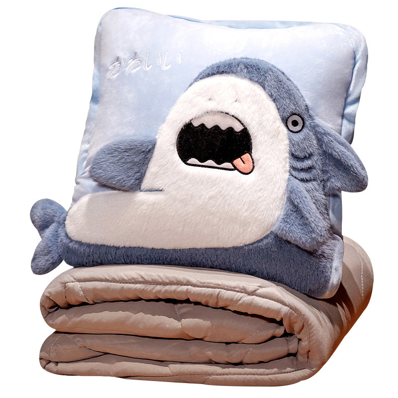 Funny shark plush pillow with folded blanket underneath, showcasing the 2-in-1 convertible cushion and throw design for sofa, bed, or office comfort