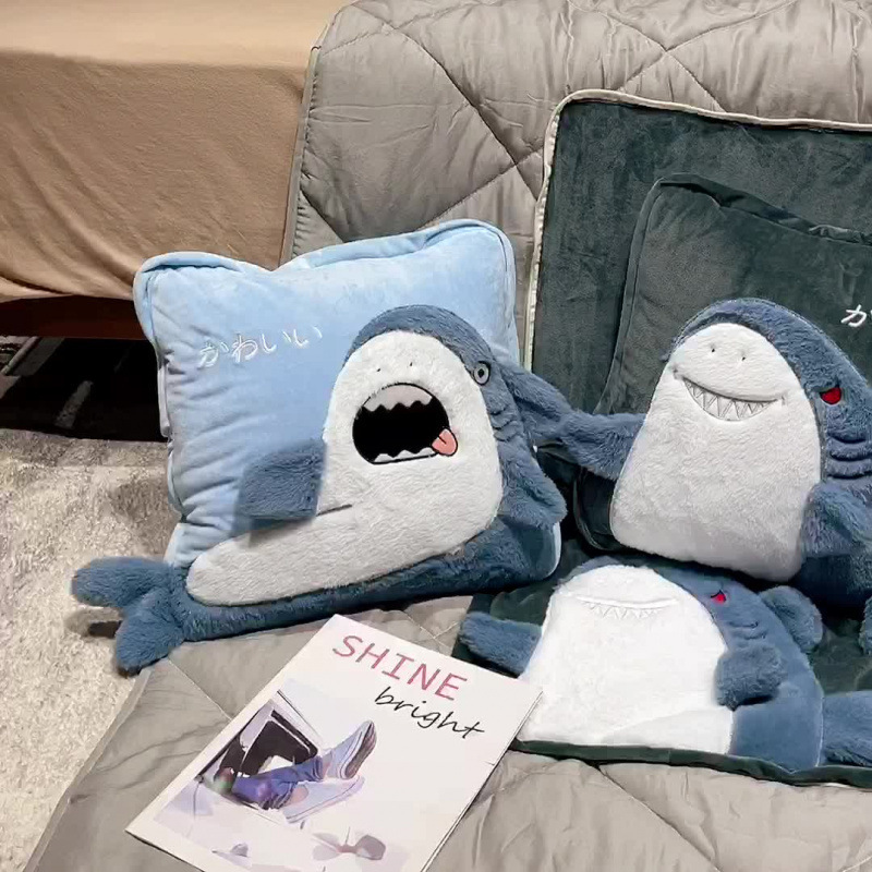 Funny and mischievous shark plush pillow blankets displayed beside a bed, highlighting the soft plush texture and cozy multifunctional home decor design