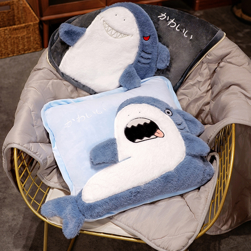Mischievous shark plush pillow blanket unfolded on a chair with the blanket spread out, while the funny shark design is shown in pillow form on top, highlighting the 2-in-1 convertible feature