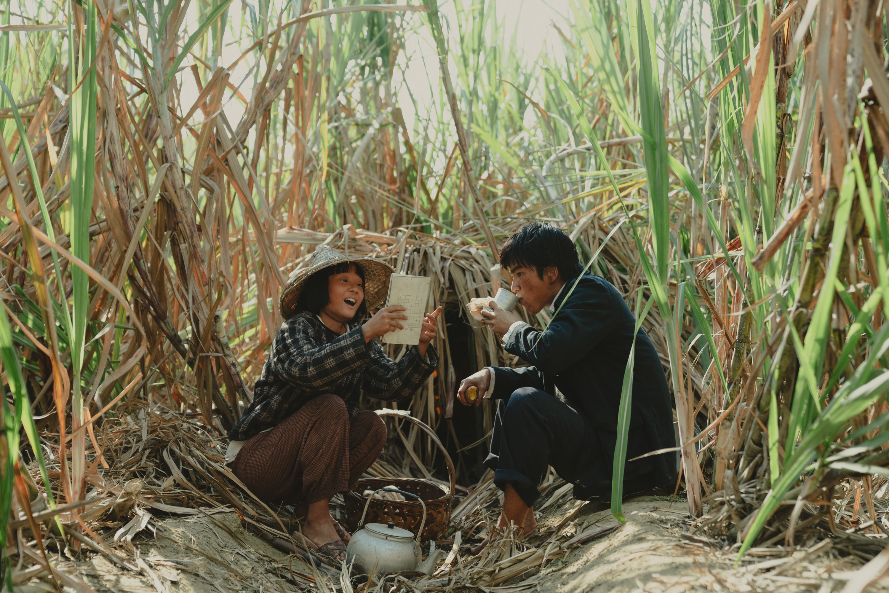 方郁婷（左）與曾敬驊（右）在電影《大濛》中，為了詮釋50年代的農村孩子，有別於以往白淨形象被「全身抹黑」。／華文創 提供