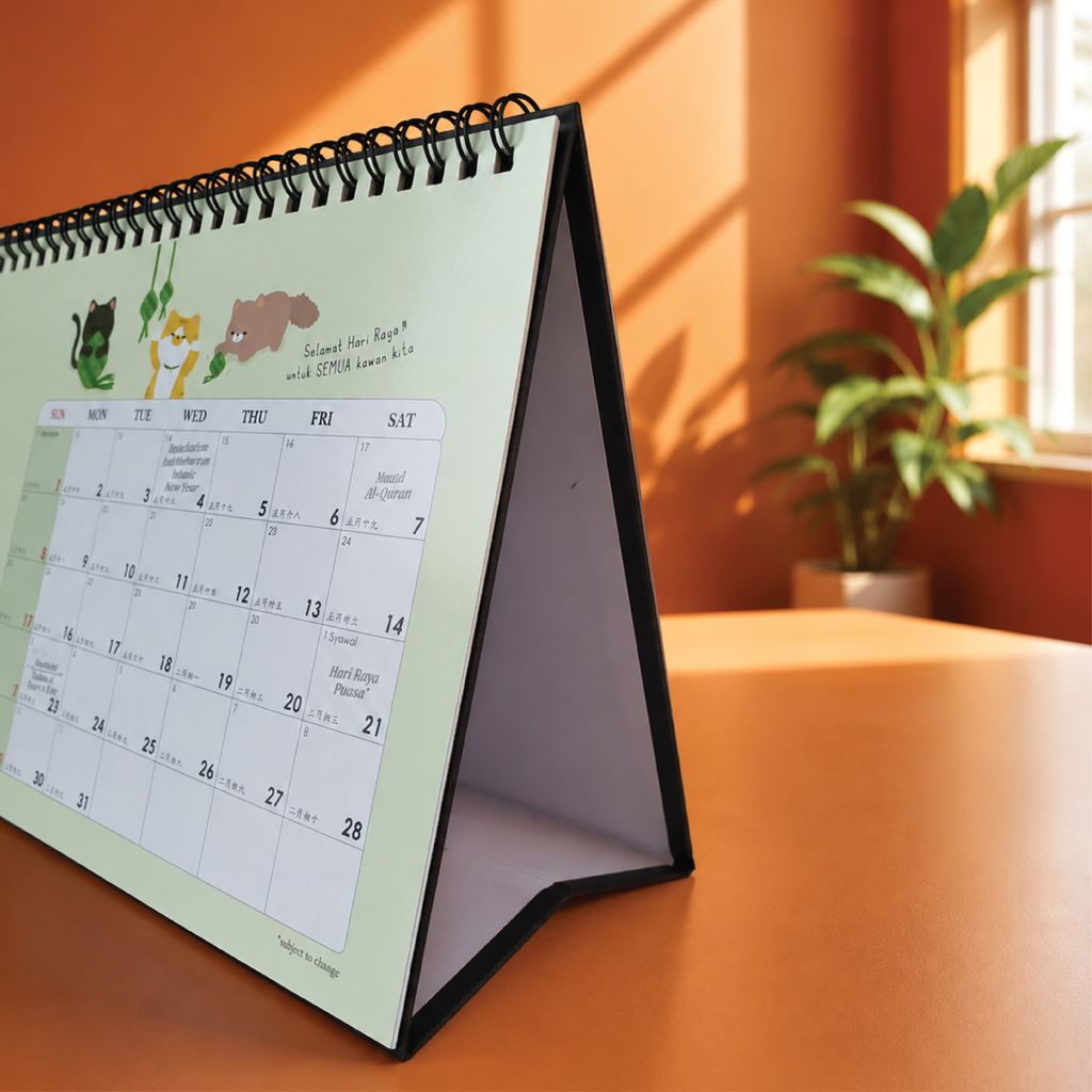 Landscape desk calendar on an office desk showing the monthly layout