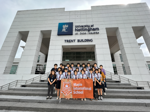 Students holding printed school flag at university group photo