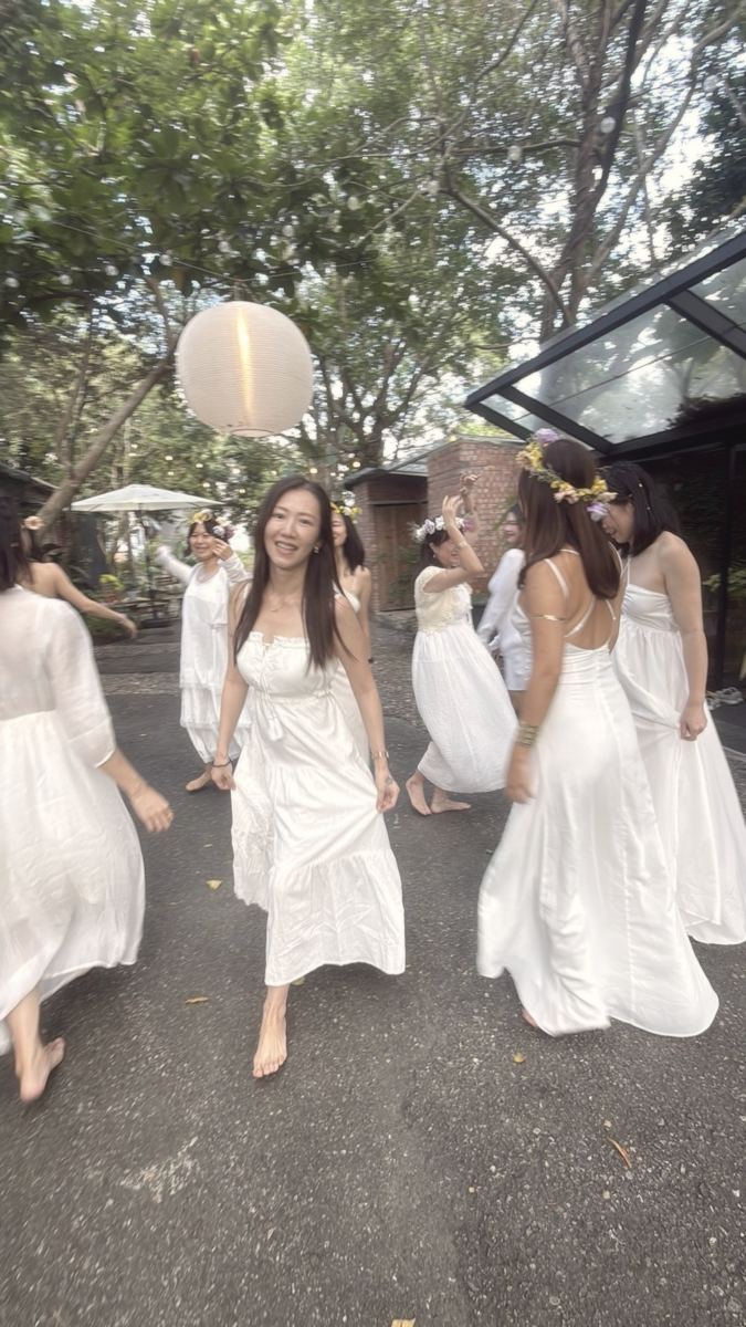 譚崔女人學員穿著白衣、戴著花冠在戶外漫步