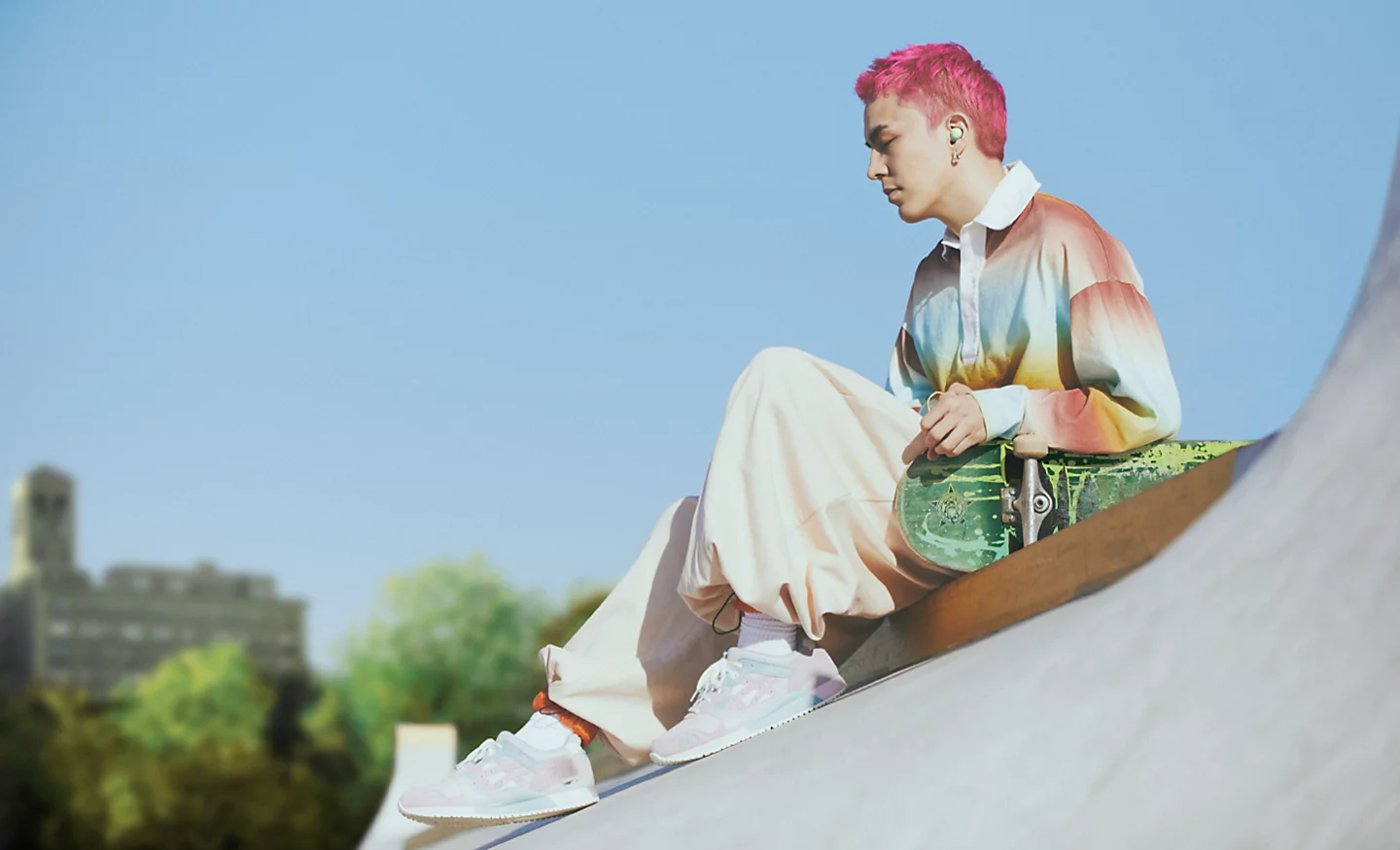 Image of a person sitting on a ramp with a skateboard wearing WF-C700N Wireless Noise Cancelling headphones